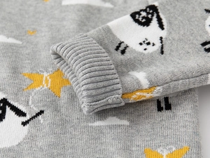 Detail of knit child sweater showing cartoon sheep pattern and ribbed cuff texture