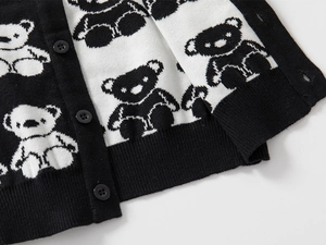 Close-up of knit cardigan featuring cartoon bear patterns and black resin buttons