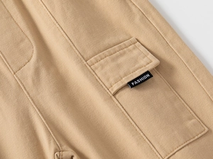 Dettaglio dei pantaloni cargo kaki per bambini in twill di cotone con etichetta moda