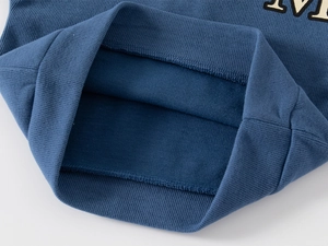 Detail of ribbed knit cuffs and soft fleece lining on blue polo collar sweatshirt
