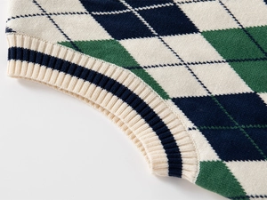 Dettaglio della maglia a rombi e dei bordi a coste su un gilet in maglia per bambini