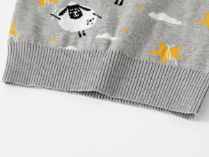 Detailed macro view of the ribbed hem on this gray knit sweater with cartoon sheep patterns