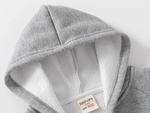 Détail de la doublure en polaire épaisse et de l'étiquette tissée d'un sweat à capuche gris