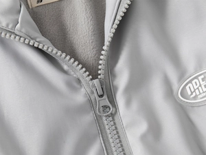 Détail d'une veste polaire enfant avec fermeture éclair en résine et doublure thermique