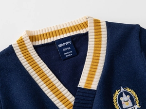 Detail of navy knit cardigan featuring V-neck striped ribbing and bear shield embroidery