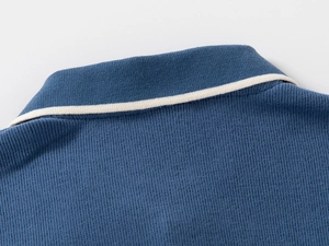 Close-up of blue knitted polo collar with white stripes on boys' casual sweatshirt