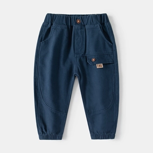 Detail of navy cotton kids joggers featuring elastic waist and utility pocket with THE tag