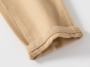 Dettaglio dei pantaloni chino kaki con trama in twill e risvolto sulla gamba con cuciture