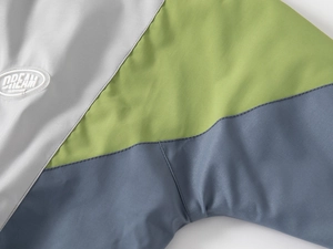 Détail d'une veste enfant avec patchwork tricolore et écusson brodé DREAM DREAM logo