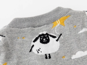 Detail of grey knitted sweater featuring ribbed neckline and cute sheep pattern