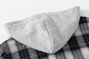 Close-up of gray hood and black-white plaid fabric texture on boy's casual shirt