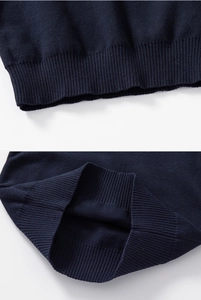 Detailed view of the dark blue ribbed cuffs and hem of the children's knitted sweater