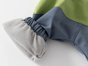 Détail du tissu extérieur coupe-vent et doublure en polaire grise de veste enfant
