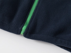 Detailed close-up of navy blue fleece jacket showing the high-density green resin zipper