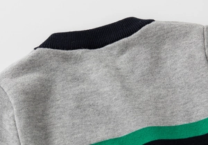 Detail of children's knit sweater featuring ribbed crew neck and contrast stripe patterns