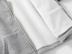 Détail de la doublure en polaire chaude blanche sur un sweat à capuche gris chiné