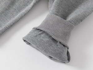 Détail du tissu en maille gaufre grise et des poignets côtelés pour pantalon enfant