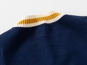 Detail of V-neck ribbed knit collar on children's navy blue cardigan sweater