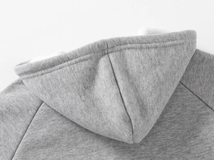 Détail d'un sweat à capuche gris avec doublure en polaire chaude et coutures nettes
