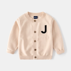 Détail du cardigan tricoté pour enfant avec boutons aspect bois et patch lettre J
