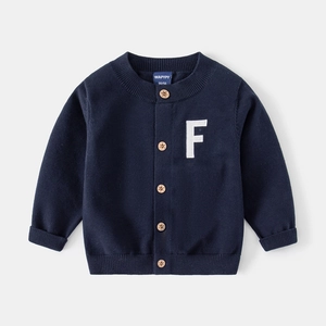 Détail du cardigan en maille bleu foncé avec boutons en bois étoilés et écusson lettre F
