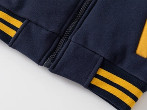 Detail of kids baseball jacket showing dark blue rib-knit hem and high-quality zipper