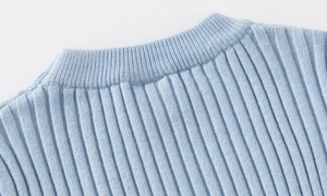 Macro view of the ribbed knit texture and soft crew neck detail on the blue sweater