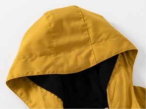 Détail de la veste jaune à capuche montrant la doublure polaire noire et le tissu coupe-vent