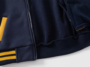 Detailed close-up of navy blue baseball jacket with thick fleece lining and yellow trim