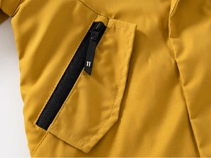 Détail de veste jaune pour enfant avec poche zippée noire et numéro 11 embossé