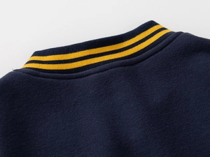 Detail of navy blue ribbed collar with yellow stripes on kids baseball jacket