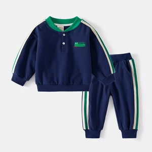 Detail of navy cotton kids sweatshirt set with green stripes and crocodile embroidery