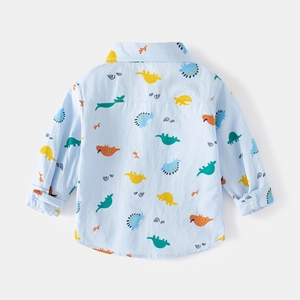 Détail d'une chemise bleu clair à manches longues pour garçon avec imprimé dinosaure au dos