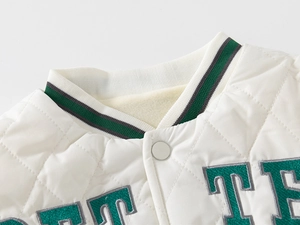Detail of cream quilted jacket with green striped collar and embroidered letters
