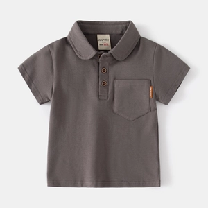 Detail of dark gray boys' polo shirt showing wood-tone buttons and chest pocket label