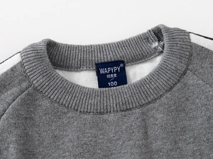 Gros plan détaillé du col du pull en tricot gris avec une finition de col côtelé de qualité