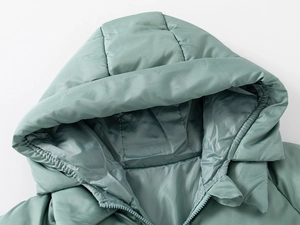 Detail view of winter padded coat neckline and hood with green windproof fabric
