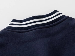 Detail of navy baseball jacket collar with classic white knit ribbed stripes and stitching