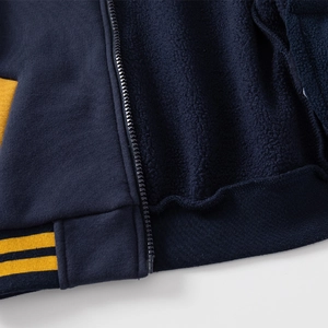 Thick navy blue boys baseball jacket with warm fleece lining and yellow striped hem