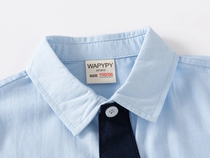 Macro view of blue cotton shirt collar with navy tie detail and inner brand label