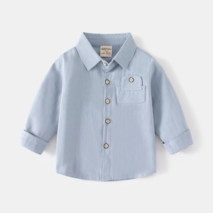 Detail of light blue cotton shirt featuring wooden buttons and a front flap pocket