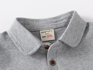 Close-up of boys gray polo shirt collar featuring wood texture buttons and cotton fabric
