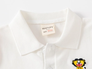 Close-up of white cotton polo shirt collar featuring a yellow lion embroidery detail