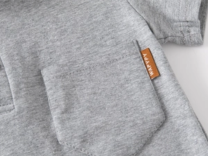 Close-up of boys gray cotton polo shirt featuring a chest pocket and brown woven label detail