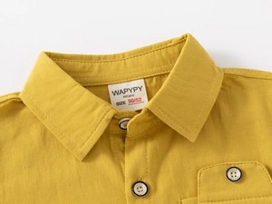 Close-up of yellow cotton shirt collar with brand label and fine stitching details
