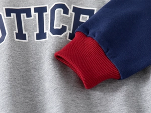 Detailed close-up of kids' pullover sweatshirt with ribbed cuffs and letter print