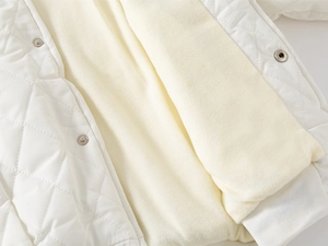 Detail shot of quilted white jacket featuring warm fleece lining and metallic buttons