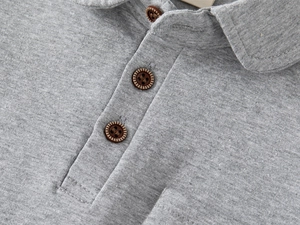 Detail of grey boys' polo shirt showing the collar and brown retro wood-textured buttons