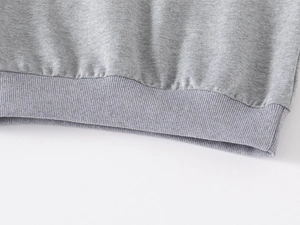 Detailed macro view of the grey ribbed hem and knitted fabric on children's sweatshirt