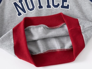 Detail of ribbed hem and NOTICE letter print on kids' vintage grey and red sweatshirt